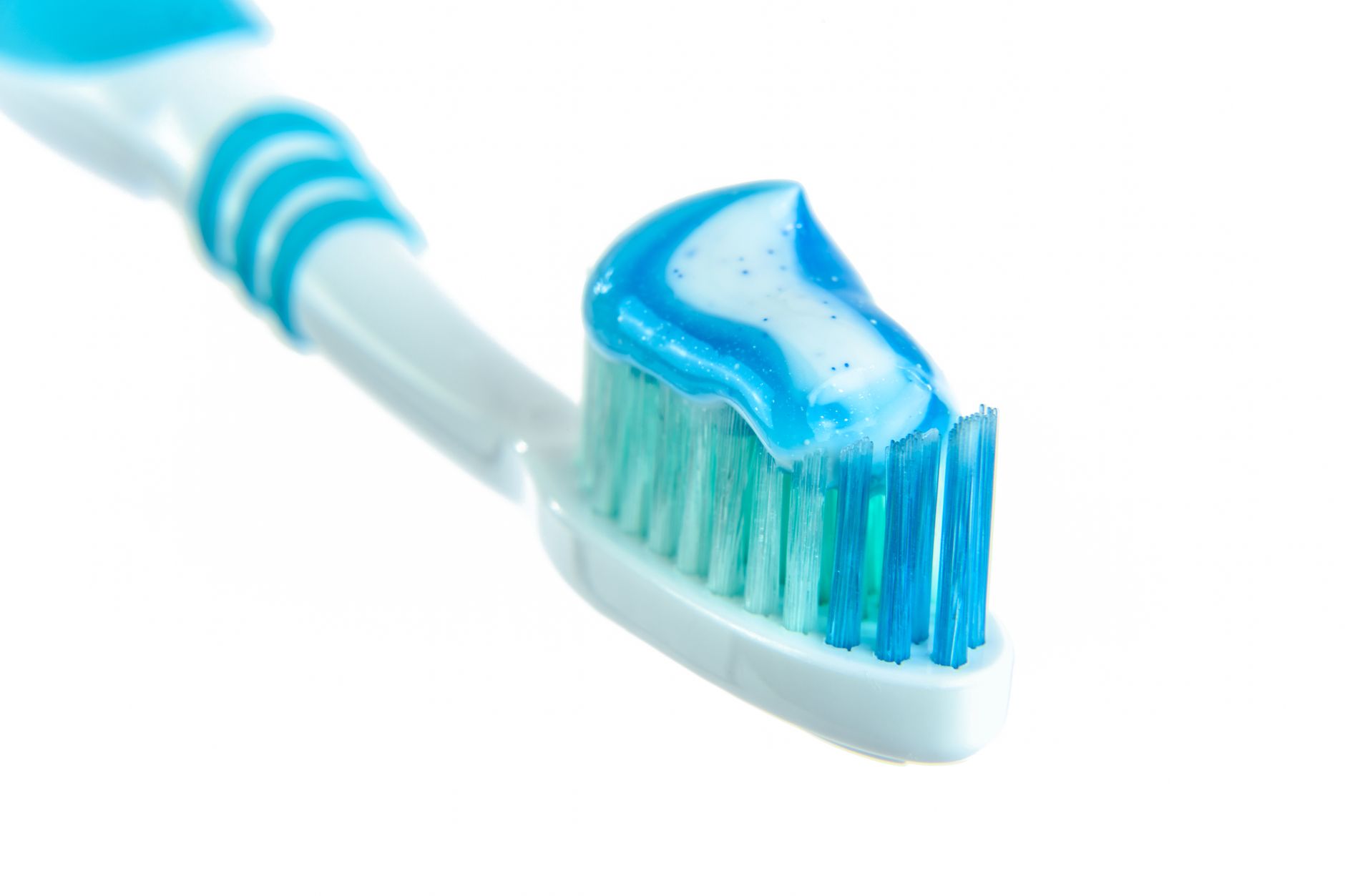 A toothbrush with blue toothpaste, representing daily dental hygiene.